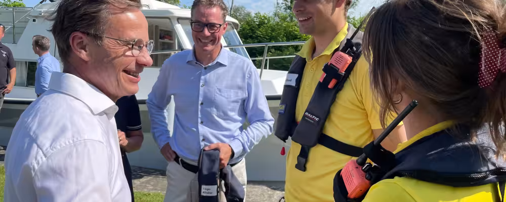 Statsminister Ulf Kristersson i samtal med slussvärdarna Lotta Schouten och Alfred Hofström samt Göta kanals vd Roger Altsäter vid Borenshults slusstrappa i Motala. foto Göta Kanal