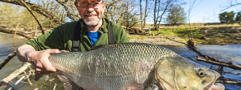 Fiskebiolog Johan Persson med en femkilosasp i Örsundaån i Enköping. Foto: Ola Jennersten