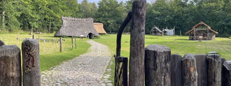 Bronsåldersgården kommer att väckas till liv av så kallade reenactors. De är historieentusiaster, klädda i periodens dräkter, som kommer att övernatta i de historiska långhusen och leva bronsåldersliv. Foto: Västra Götalandsregionen