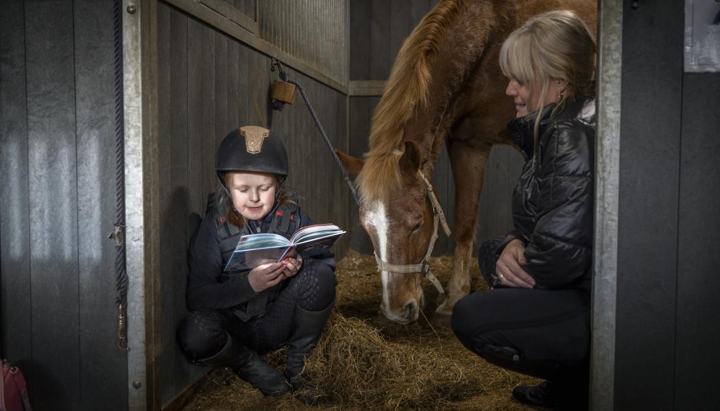 Läsläxan gör Molly bäst i stallet. Här med Champis och mamma Maria. Foto: Susanne Walström