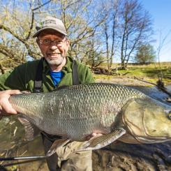 Fiskebiolog Johan Persson med en femkilosasp i Örsundaån i Enköping. Foto: Ola Jennersten