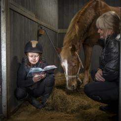 Läsläxan gör Molly bäst i stallet. Här med Champis och mamma Maria. Foto: Susanne Walström