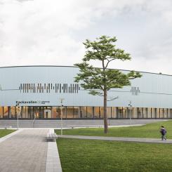 Backavallens sporthall byggs i trä med stående träpanel och stora glaspartier. Visionsbild: D-office